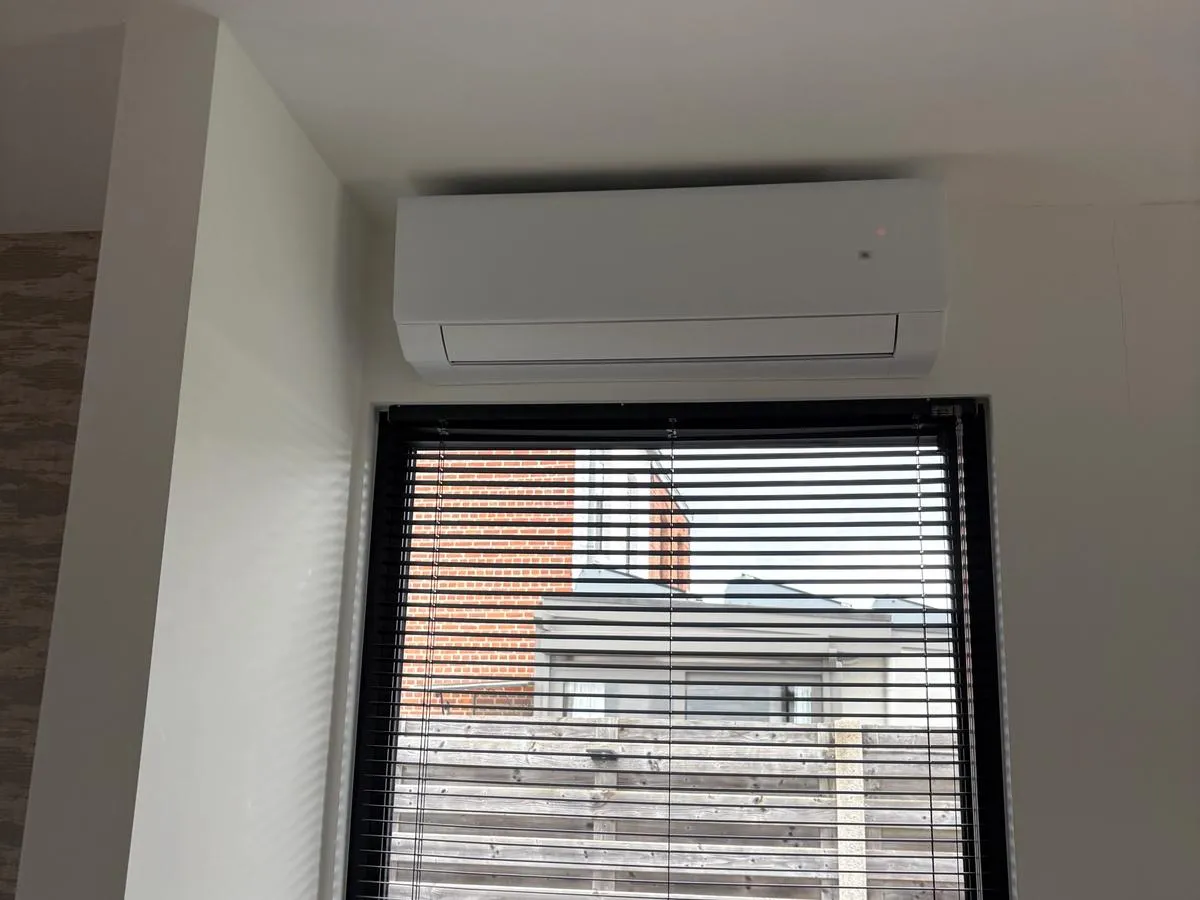 Witte Gree-binnenunit boven een raam in Averbode
